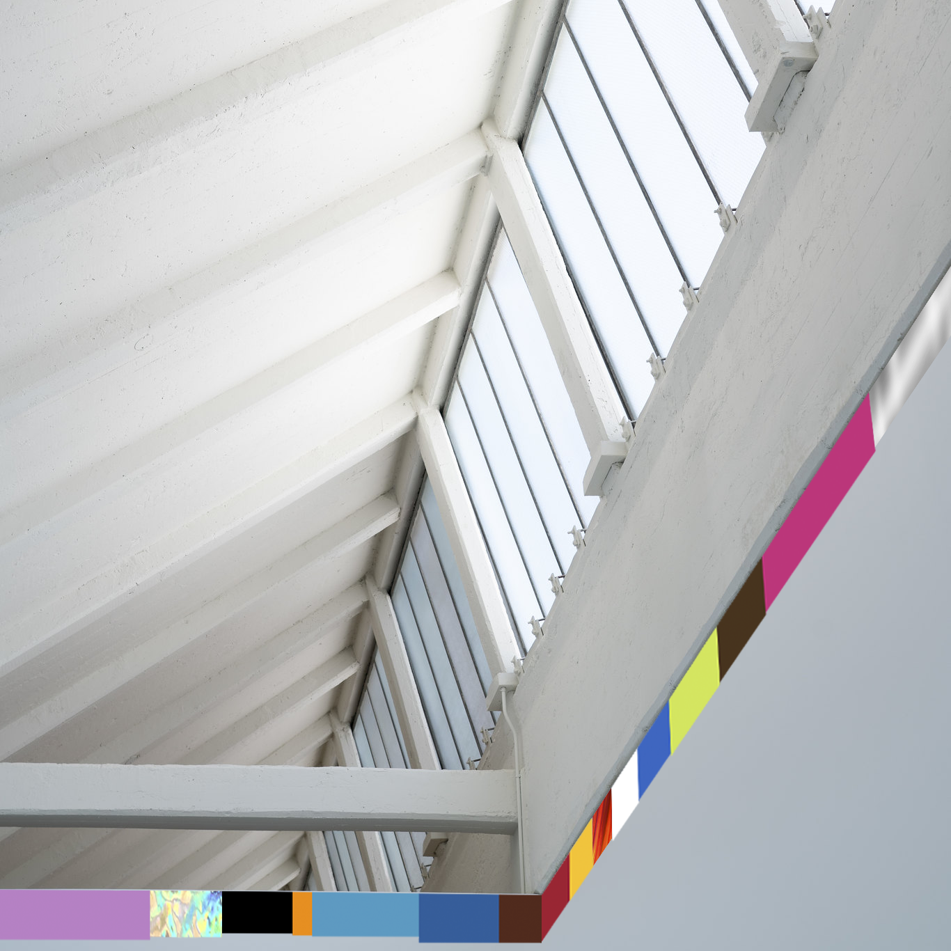 brightly colored strips of advesive vinyl of random color and length installed at the top of the wall as wall meets ceiling in a postindustrial contemporary art exhibition musuem as if at the dia beacon by artist noah travis phillips